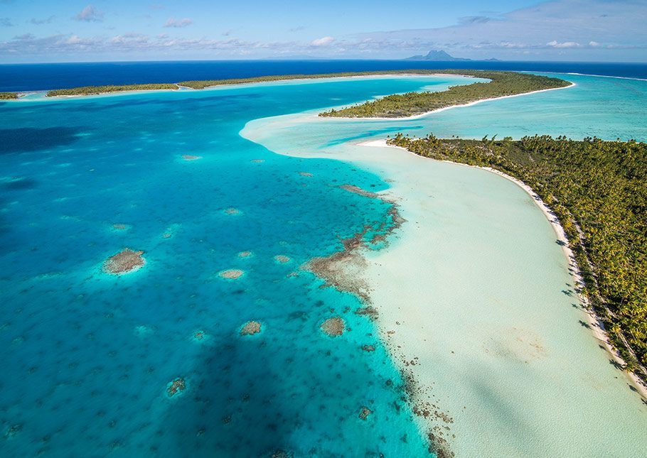 Bora Bora Beach with Clear Turquoise Waters and a Variety Cruises Yacht